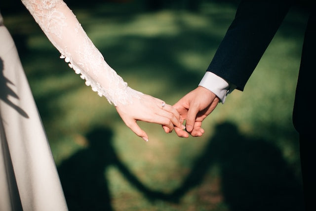 Couple holds hands during their wedding day.